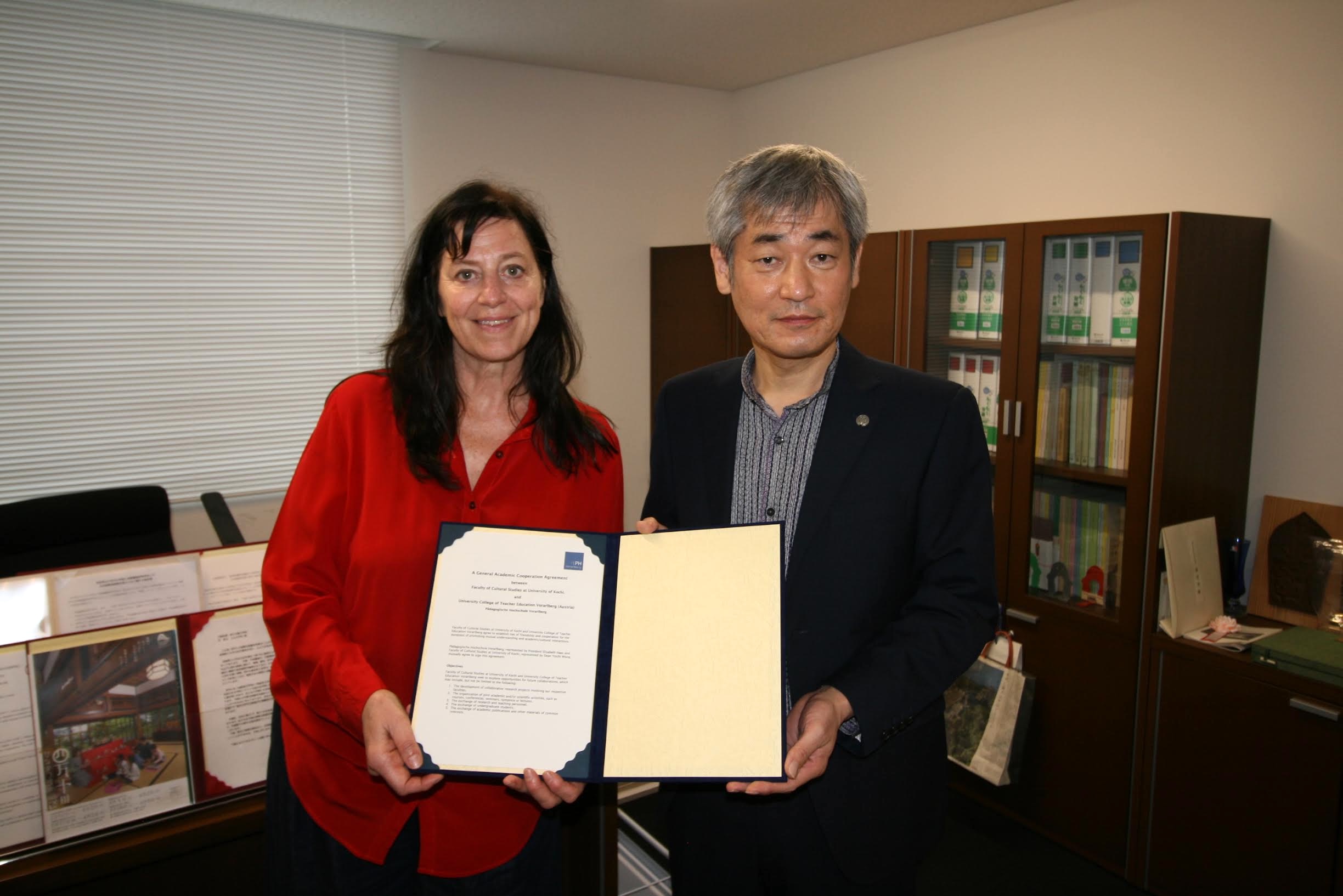 協定書を示すベレットセンター長と三浦学部長