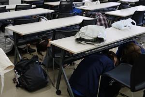 机の下への非難の様子